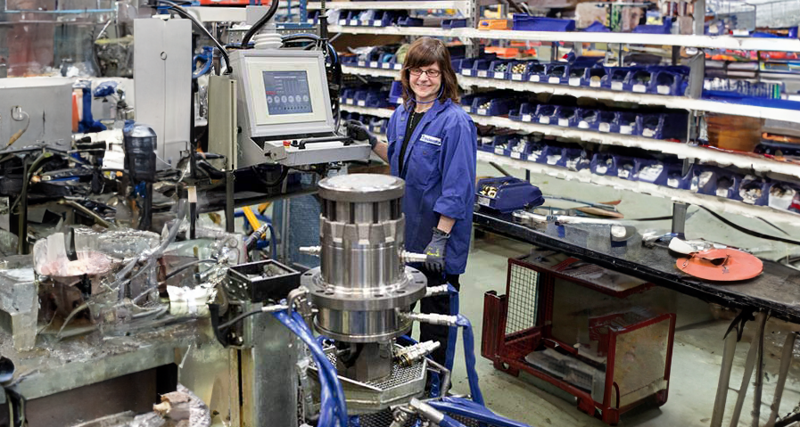 En kvinna står i en fabrik.