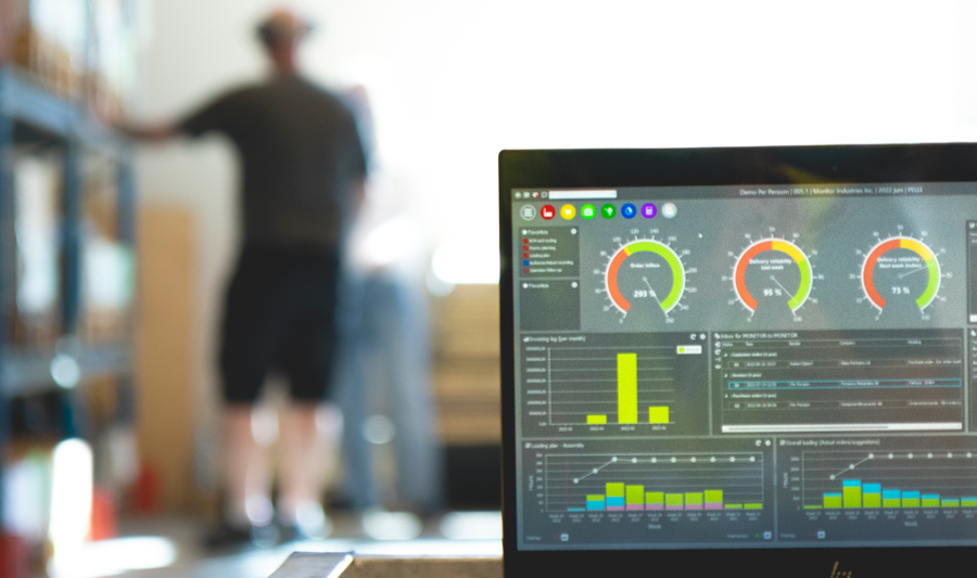 Monitor ERP dashboard displayed on a laptop in a factory environment