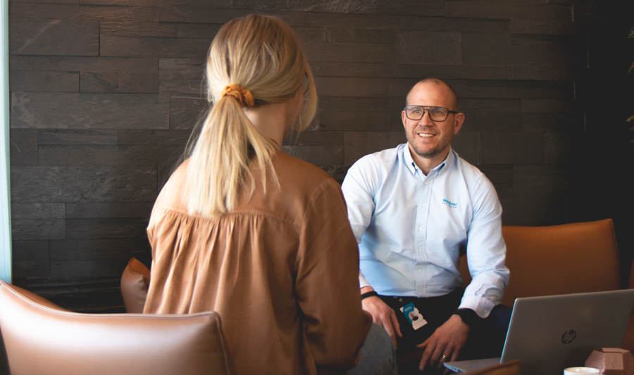 A man and a woman sitting at a table and talking to each other.
