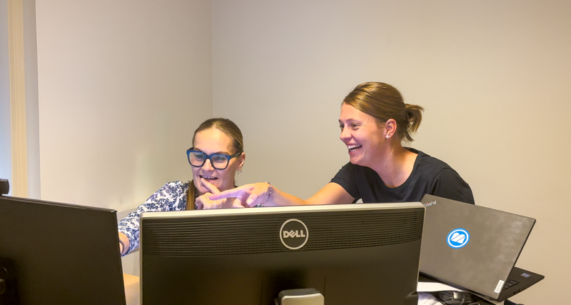Two co-workers from BM Silo sitting in front of a computer.