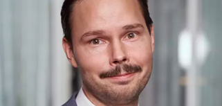 Erik Ståhlsten, IT-manager på Harald Pihl står bakom en grå bakgrund.