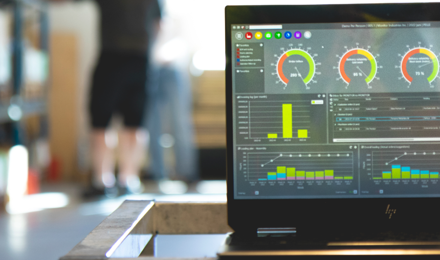 Monitor ERP dashboard displayed on a laptop in a factory environment