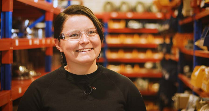 En kvinna står i en fabrik.