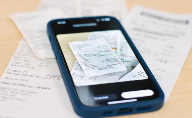 A smartphone scanning paper receipts