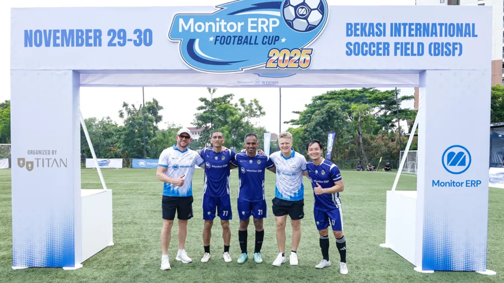 A group of five men, representing Monitor ERP and Titan, posing for a photo under the event archway for the Monitor ERP Football Cup 2025