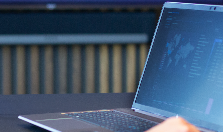 Laptop oraz ekran pokazujący system Monitor ERP