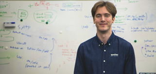 Viktor Rosvall, Utvecklare på Monitor, står framför en white board. 