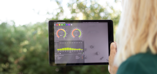Illustration of Monitor ERP dashboards on a screen placed in nature, symbolizing sustainability.