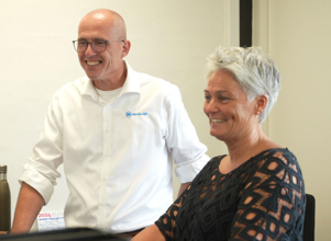 A man and a woman sitting in front of a computer.