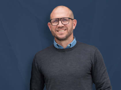 Johan Holmsten, global sales manager at Monitor ERP, standing infront of a blue background