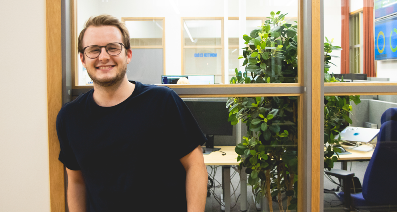 Anton Bergström står och ler och kollar in i kameran. 