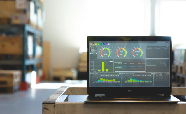 Monitor ERP dashboard displayed on a laptop in a factory environment