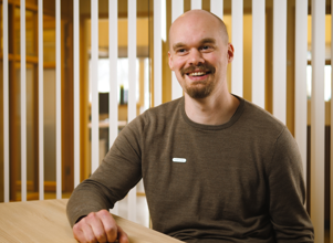 Man in an office with a green jumper