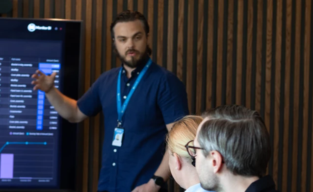 En person från Monitor ERP håller en presentation för en grupp människor om Monitor BI (business intelligence).