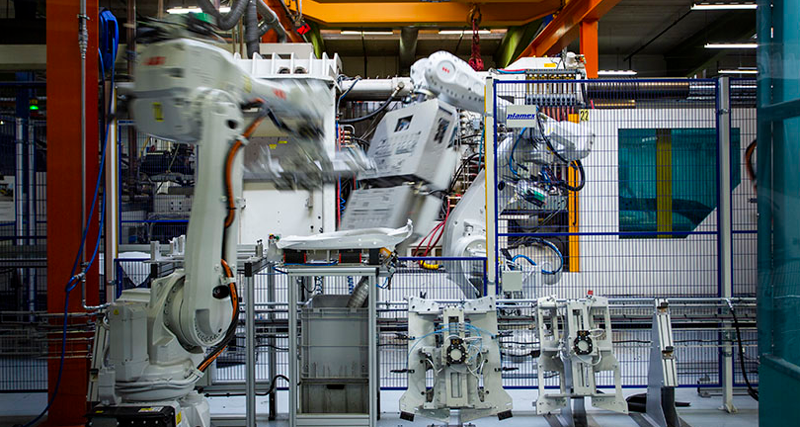 En stor maskin i en byggnad med en lyftkran i bakgrunden.