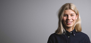 A woman in a black shirt is smiling.
