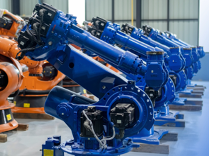 En rad orangea och blå maskiner i ett lager.