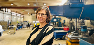 En kvinna står i en fabrik.