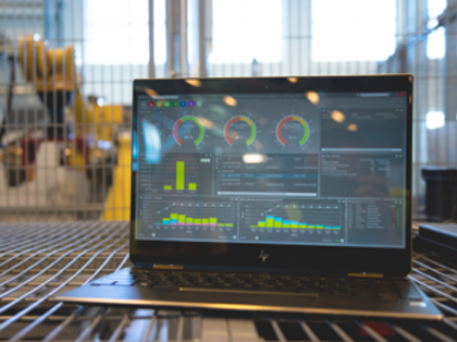 Monitor ERP dashboard displayed on a laptop in a factory environment