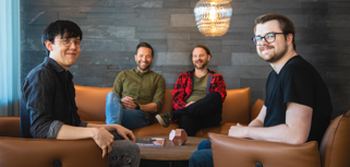 Martin Karlsson och Rasmus Lindberg sitter med två andra kollegor i en soffgrupp på huvudkontoret.