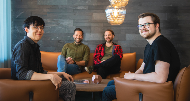 Martin Karlsson och Rasmus Lindberg sitter med två andra kollegor i en soffgrupp på huvudkontoret.