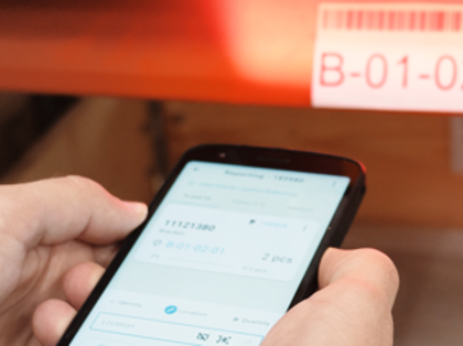 En person skannar en palletikett med mobiltelefonen med hjälp av Monitor Mobile.