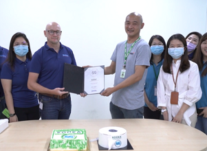 Men and woman in a factory after signing a contract