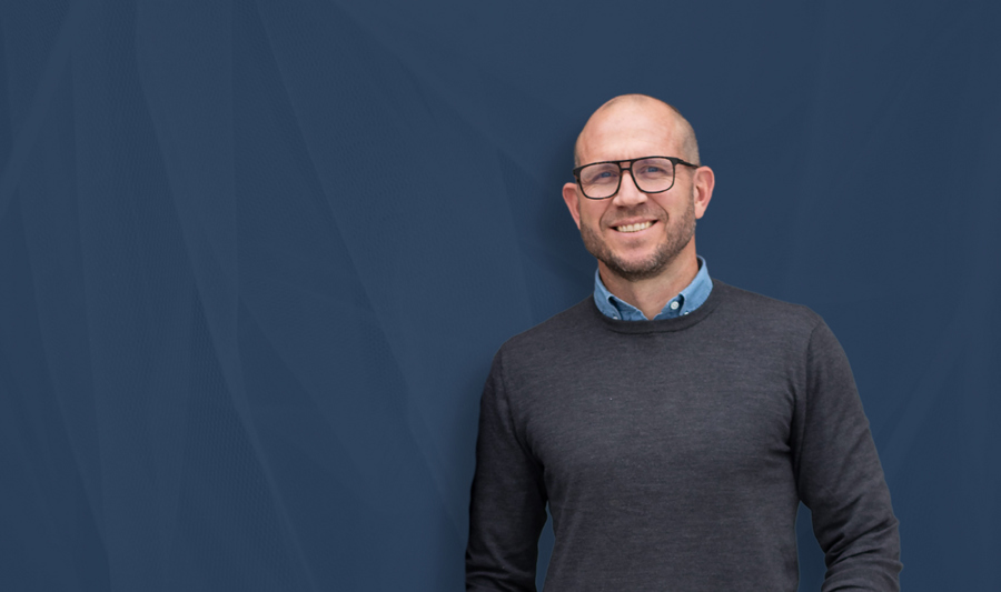 Man in a grey jumper smiling