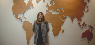 Hazal Kiliç standing in front of a worldmap