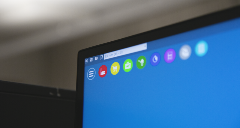 En närbild av en datorskärm med blå bakgrund som visar Monitor ERP.