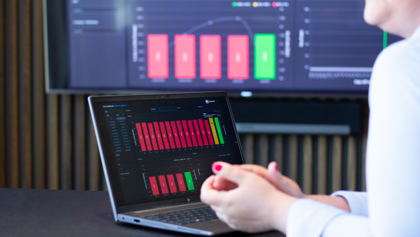 A person sitting in front of a laptop computer with Monitor BI (business intelligence) dashboards. 