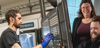 Två killar och en tjej står i en verkstad.