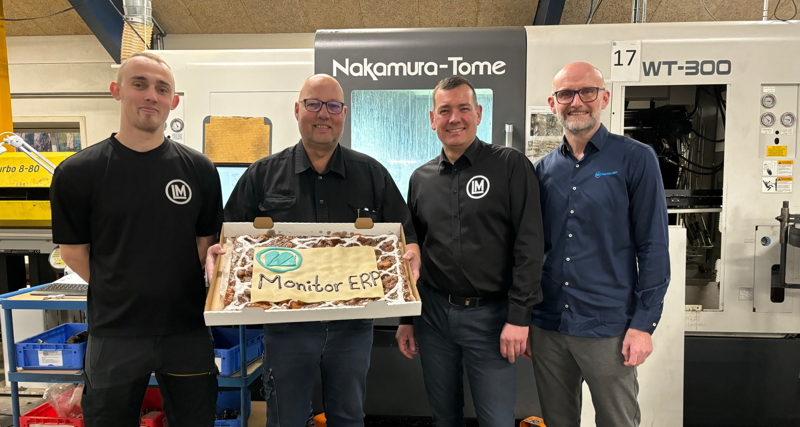 Employees from Lund Maskinfabrik A/S are standing and holding up a cake with “Monitor ERP” written on it.