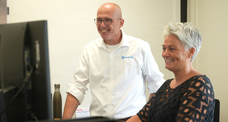 A man and a woman sitting in front of a computer.