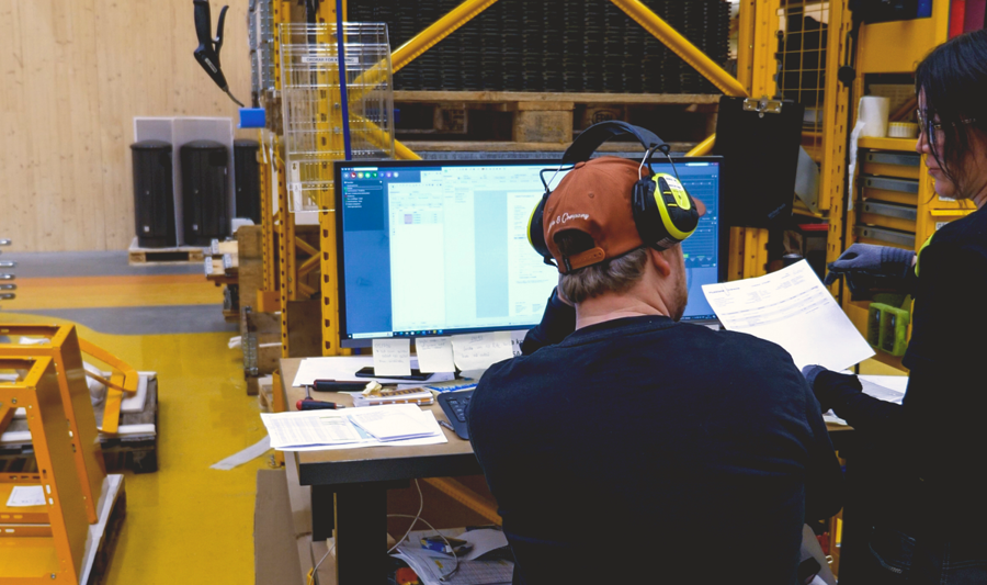 Två personer står i en fabrik och använder Monitor ERP