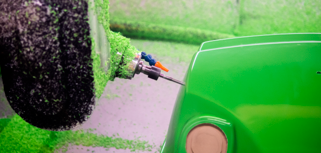 A green machine with a hose connected to it.