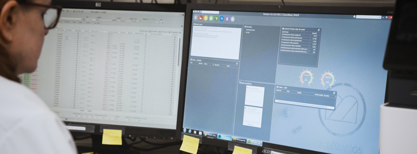 A man sitting in front of two computer monitors.