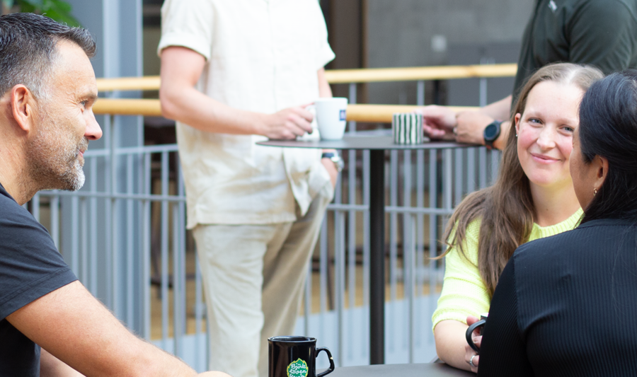 Employees at Monitor sitting and drinking coffee.