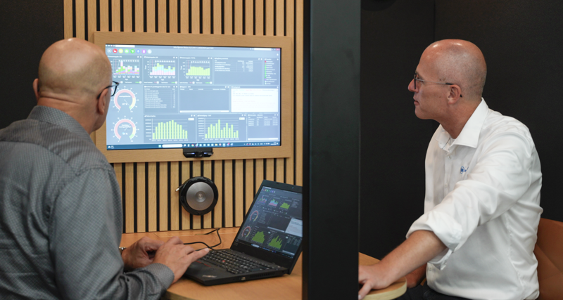 Jesper and Arne from Bjerrum Nielsen looking at a computer with Monitor ERP Dashboard.
