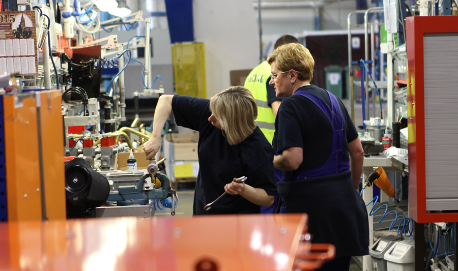 A group of people standing in a factory environment. 