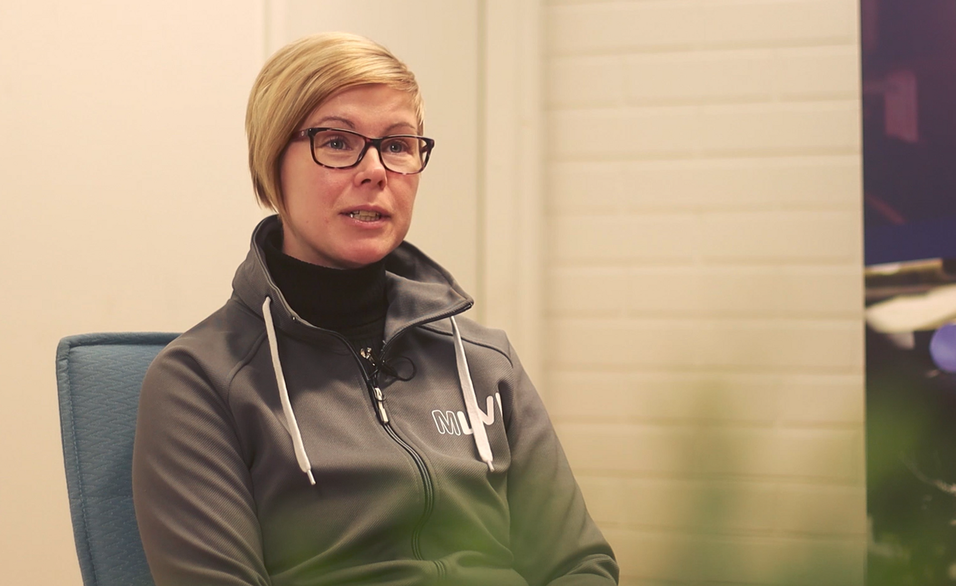 En kvinna sitter på en stol.