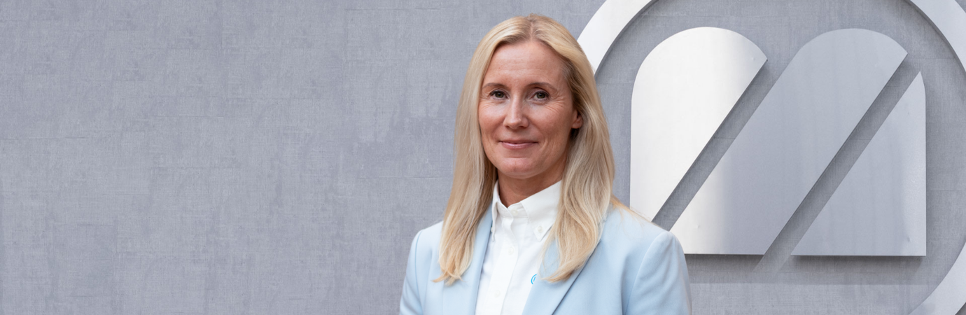 A woman standing in front of a logo.