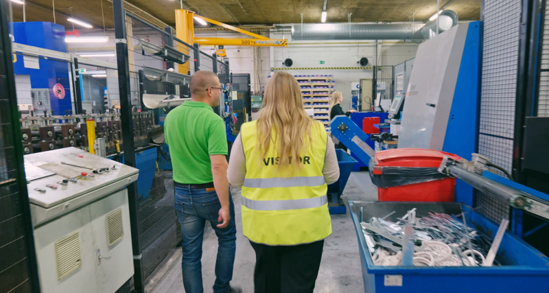 A man and a woman walking through a factory.