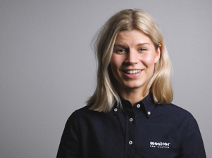 A woman in a black shirt is smiling.